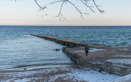 Odessa, Ukraine - 12.27.2018. Lonely people on the pier by the sea on a sunny winter dayのeditorial素材