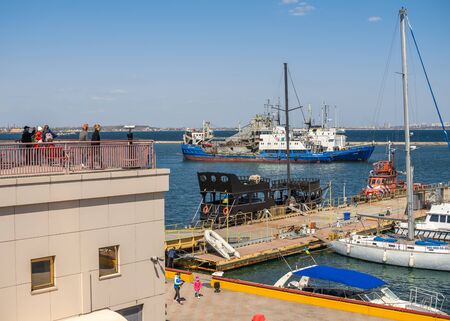 Odessa, Ukraine - 04.20.2019. Tourists look at the harbor and seaport of Odessa on a sunny spring dayのeditorial素材