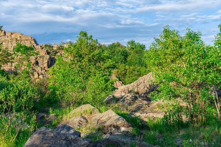 The rocky banks of the Southern Bug River near the village of Migiya in Ukraine on a sunny summer dayの写真素材