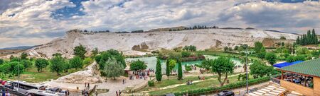 Pamukkale, Turkey â 07.14.2019. White mountain and green lake in Pamukkale. Panoramic view from the side of the village on a cloudy summer evening.のeditorial素材