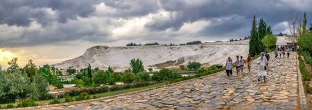 Pamukkale, Turkey â 07.14.2019. White mountain and green lake in Pamukkale. Panoramic view from the side of the village on a cloudy summer evening.のeditorial素材