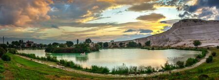 Pamukkale, Turkey â 07.15.2019. White mountain and green lake in Pamukkale. Panoramic view from the side of the village on a summer morningの写真素材