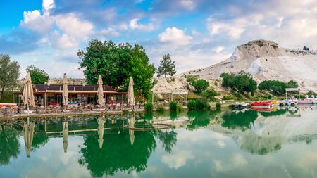 Pamukkale, Turkey â 07.15.2019. White mountain and green lake in Pamukkale. Panoramic view from the side of the village on a summer morningの写真素材