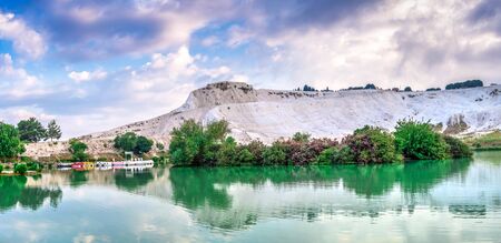 Pamukkale, Turkey â 07.15.2019. White mountain and green lake in Pamukkale. Panoramic view from the side of the village on a summer morningの写真素材