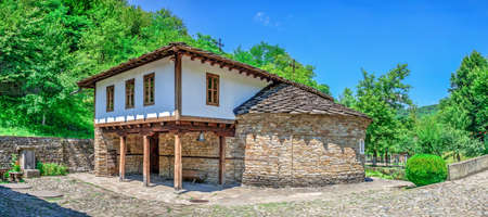 Epiphany Church with a school in the Etar Architectural Ethnographic Complex in Bulgaria on a sunny summer day. Big size panoramic photo.のeditorial素材