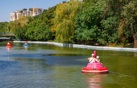 Odessa, Ukraine 08.30.2019.People ride a boat on a pond in Victory Park in Odessa, Ukraine, on a...