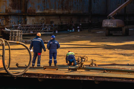 Chernomorsk, Ukraine. 03/21/2021. Dry dock workers in the dock of the Chernomorsk Shipyard