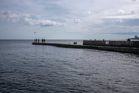 Odessa, Ukraine 19.02.2023. People walk by the sea on a cloudy winter day on Lanzheron beach in Odessa, Ukraineのeditorial素材