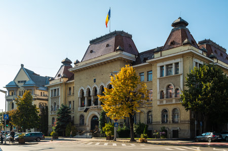 Targu Mures, Romania - October 17.2025. A wide angle view of the Cultural Palace, Prefectural Palace, and street in Targu Mures with autumn foliage under a clear skyのeditorial素材