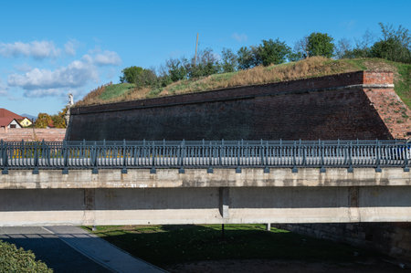 Alba Iulia, Romania - October 19.2025. A sprawling paved moat area surrounded by massive brick fortification walls and bastions under a clear blue sky in Alba Iuliaのeditorial素材