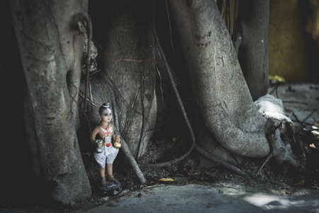 A horror boy doll under the treeの写真素材