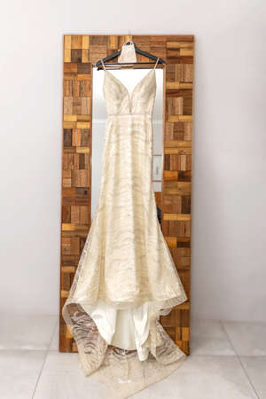 Wedding dress hanging against a mirrorの写真素材