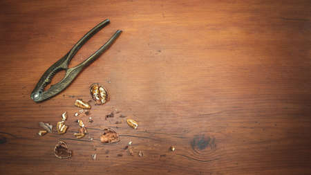 Vintage Nut Cracker with pecan nuts on a wood tableの写真素材