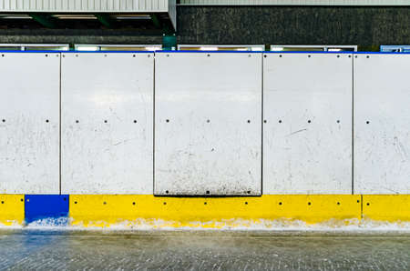 Hockey rink side boards with door and scratched and damaged surfaceの写真素材