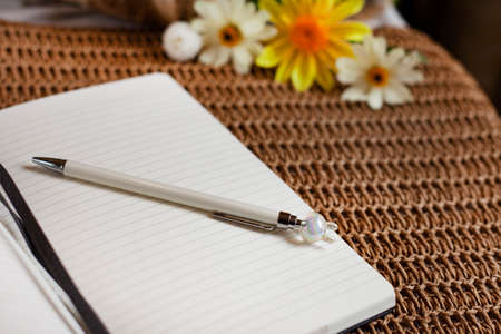 Classic lined notebook and pen in a natural rustic table setting with soft selected focusの写真素材