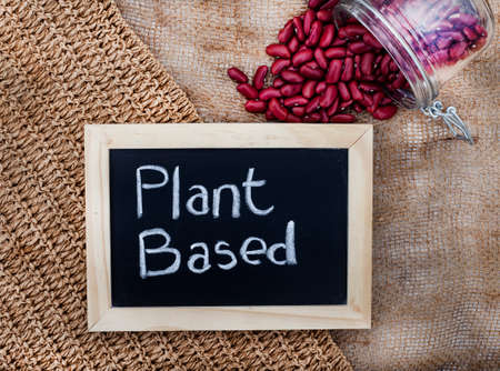 Mixture of plant-based protein options with chalk board sign with plant based written on it