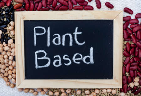 Mixture of plant-based protein options with chalk board sign with plant based written on it