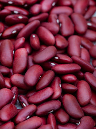 Bowl of raw uncooked red kidney beans on rustic surface