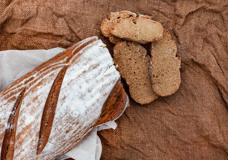 Loaf of fresh Rye bread on rustic background with copy space