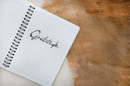 Notebook with the word Gratitude written on it. Placed on a rustic surfaceの写真素材