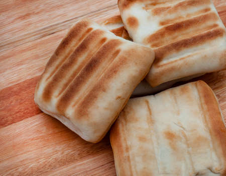 Traditional South African Braai bread or roosterbrood, cooked on open flame with rustic style backgroundの写真素材