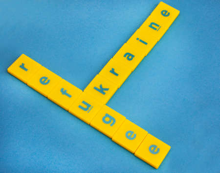 Yellow and blue scrabble tiles spelling Ukraine and refugeeの写真素材