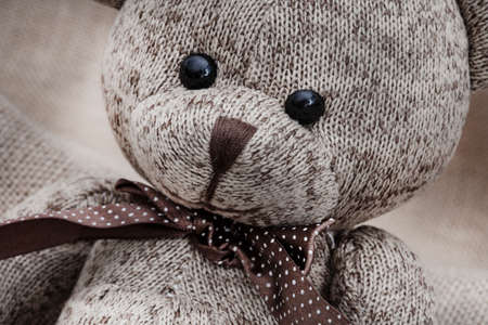 rustic style teddy bear on hessian and rough fabric with war time toys, illustrating a childhood...