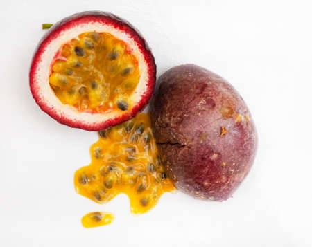 Granadilla or passion fruit, cut open with pulp on white backgroundの写真素材