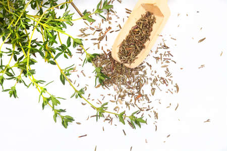 dried thyme herbs in wooden scoop on rustic surfaceの写真素材