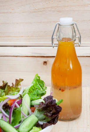 homemade salad dressing with side salad on rustic table with copy space