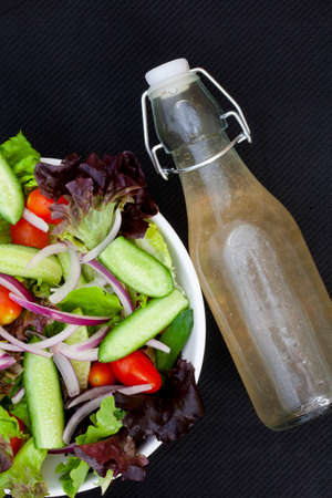 flat lay of homemade salad dressing with side salad on rustic table with copy spaceの写真素材