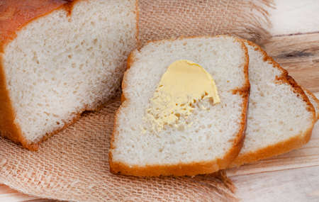 sliced fresh home baked white farm bread on rustic table with copy space