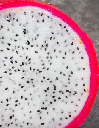 Dragon fruit slices on grey mottled surface and ample copy spaceの写真素材