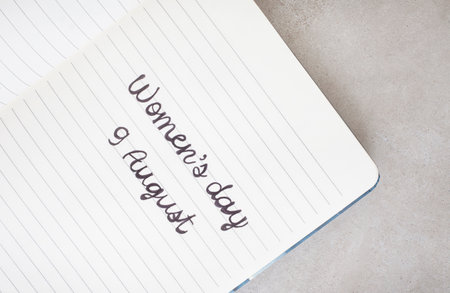South Africa national womanâ€™s day 9 august written on notebook with rustic background and...