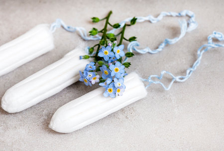 female hygiene, tampons and forget-me-not flowers on greyの写真素材