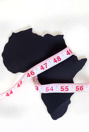 black cut out of Africa continent on white with measuring tape wrapped around it