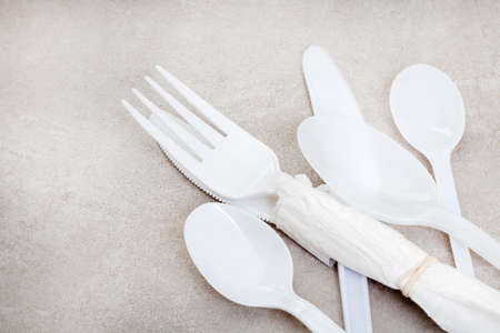 White plastic cutlery on mottled grey with copy spaceの写真素材