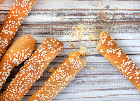 A traditional favorite snack from Italy, Grissini or bread sticks covered with sesame seeds with copy spaceの写真素材