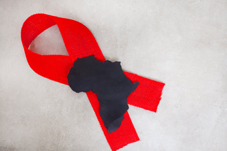 red ribbon for world Aids Day 1 December. Ribbon and Africa on mottled grey