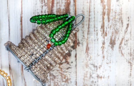 Rustic wooden flat lay, Christmas background with African beaded Christmas ornaments with copy spaceの写真素材
