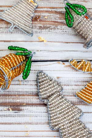 Rustic wooden flat lay, Christmas background with African beaded Christmas ornaments with copy spaceの写真素材
