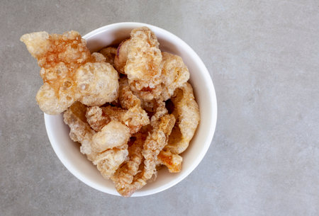 Perfectly crisp, pork rind or crackling in white bowl with copy spaceの写真素材