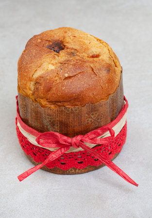 small Panettone on mottled gray with Christmas ribbon
