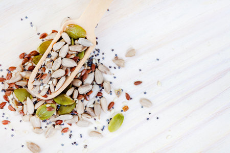 Healthy food background with sunflower seeds and pumpkin seeds on wooden spoonの写真素材