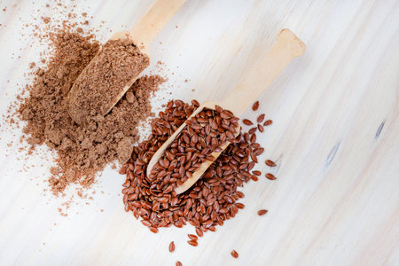 Flax seeds and linseed in wooden spoons on wooden backgroundの写真素材