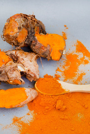 Turmeric rhizomes and powder flat lay on grey with copy spaceの写真素材