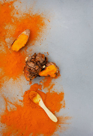 Turmeric rhizomes and powder flat lay on grey with copy spaceの写真素材