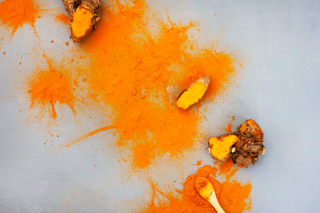 Turmeric rhizomes and powder flat lay on grey with copy spaceの写真素材