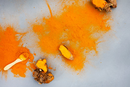 Turmeric rhizomes and powder flat lay on grey with copy spaceの写真素材
