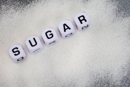Sugar written in letter dice on white sugar granulesの写真素材
